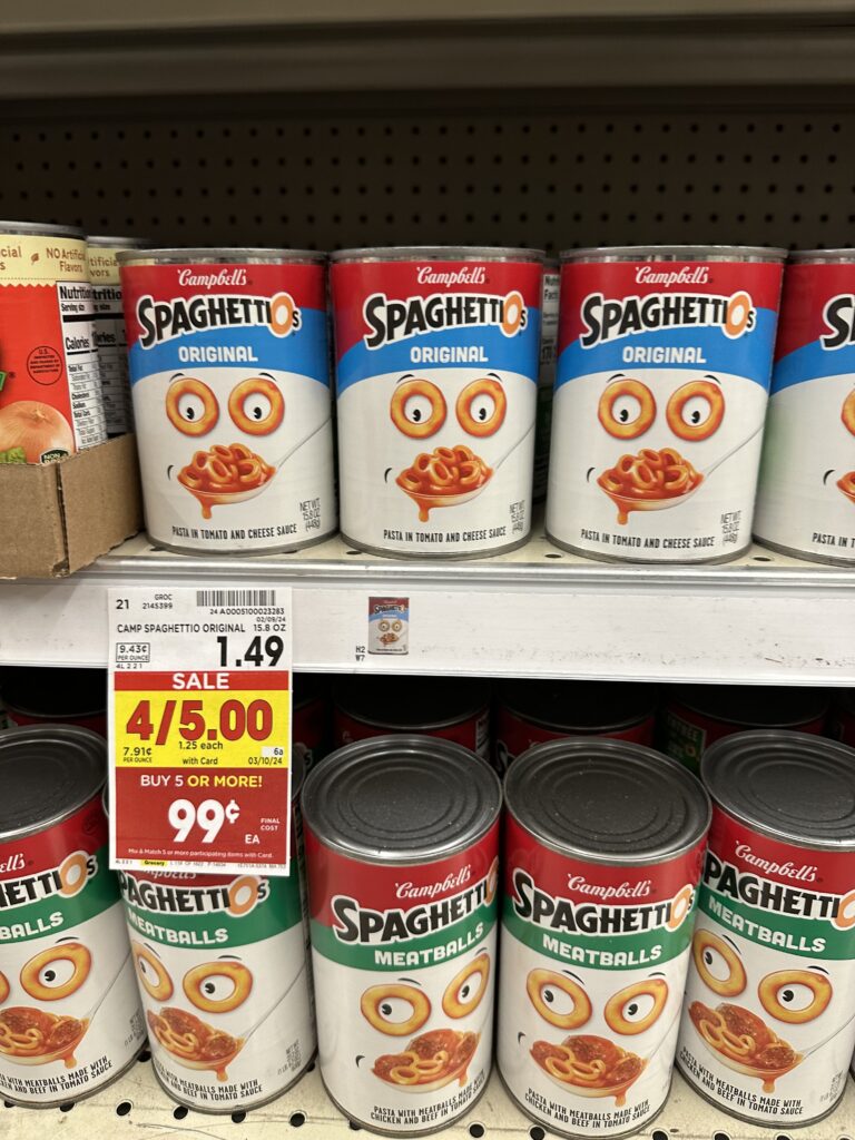 Two cans of spaghetti sauce on a shelf in a grocery store.
